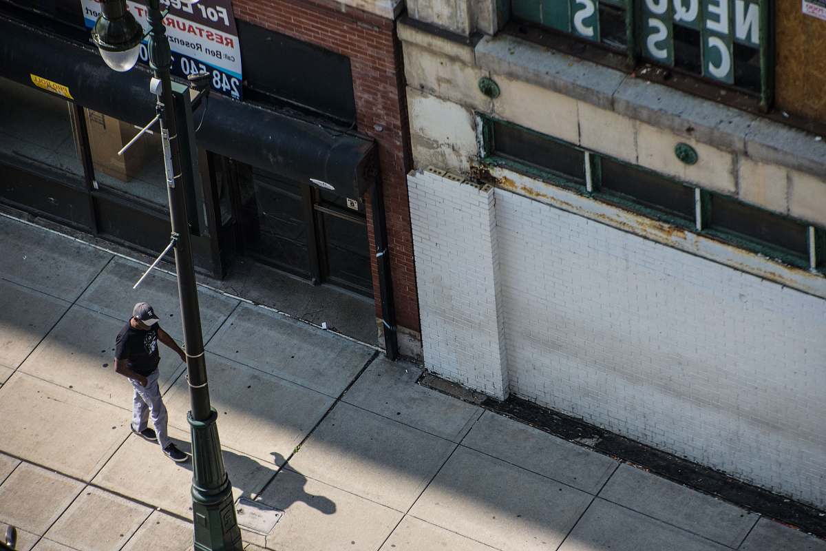 united states person walking on pedway beside utility pole grey